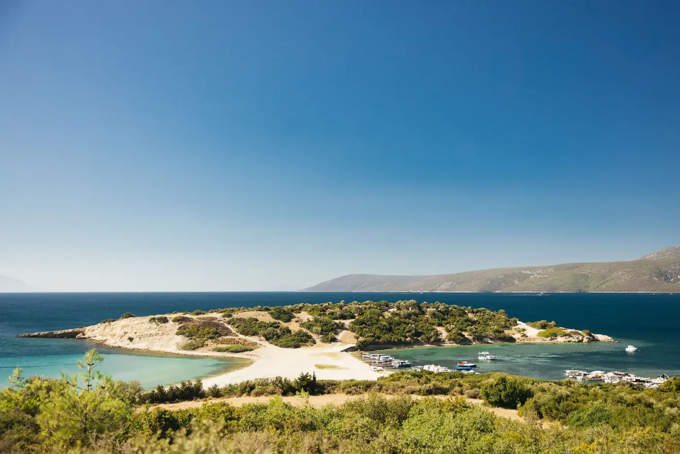 Turquoise bay with boats on the Aegean coast